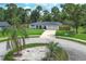 Front exterior of the home showing the front yard with mature landscaping, a long driveway, and a two-car garage at 300 Royal Palm Ct, Longwood, FL 32779