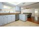 Bright kitchen with light blue cabinets, stainless steel appliances, and breakfast bar seating at 300 Royal Palm Ct, Longwood, FL 32779