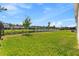 Large, well-maintained backyard with lush green grass, pond view, and black metal fencing at 3123 Camden Way, Davenport, FL 33837