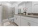 Bathroom featuring double sinks, white cabinets, tile floors, and glass shower with tile surround at 3123 Camden Way, Davenport, FL 33837
