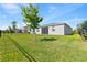 Backyard showing the home's exterior, fenced yard, green grass, and mature trees at 3123 Camden Way, Davenport, FL 33837