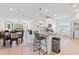 Open-concept kitchen featuring a large island with seating, modern appliances, and a dining area at 3123 Camden Way, Davenport, FL 33837