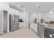 Bright kitchen features stainless steel appliances, white cabinets, tile flooring, and a pantry closet at 3123 Camden Way, Davenport, FL 33837
