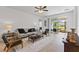 The living room features a sofa, arm chairs, a ceiling fan, and a view to the lanai at 3123 Camden Way, Davenport, FL 33837