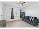 A living room features a gray sofa with a ceiling fan and large window at 3123 Camden Way, Davenport, FL 33837