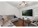 Comfortable living room with plush gray sectional, ceiling fan, and a large wall-mounted television at 3511 Superior Ct, Orlando, FL 32810