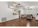 Open-concept living room with hardwood floors, ceiling fans, and a view into the adjacent kitchen at 3511 Superior Ct, Orlando, FL 32810