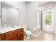 Bathroom with vanity, toilet, shower and glass door leading to outdoor, featuring neutral color scheme at 3753 Heirloom Rose Pl, Oviedo, FL 32766