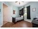 Comfortable bedroom with wood floors, ceiling fan, and a door leading to another room at 3753 Heirloom Rose Pl, Oviedo, FL 32766