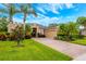Charming home with a well-manicured lawn, palm trees, lush landscaping, and a brick driveway for curb appeal at 3753 Heirloom Rose Pl, Oviedo, FL 32766