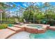 Screened-in pool area with a jacuzzi and lounge chairs, featuring serene greenery offers private outdoor relaxation at 3753 Heirloom Rose Pl, Oviedo, FL 32766