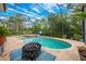 Screened-in pool area with a firepit, jacuzzi, lounge chairs, and lush greenery offers private outdoor relaxation at 3753 Heirloom Rose Pl, Oviedo, FL 32766