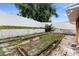 View of raised garden beds on the side of the house with a white fence in the background at 40 Hollow Pine Dr, Debary, FL 32713