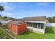 Backyard with a brick house, screened patio and outbuilding next to the white vinyl fence at 40 Hollow Pine Dr, Debary, FL 32713