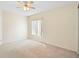 Carpeted bedroom features a ceiling fan and a large window allowing for lots of natural light at 40 Hollow Pine Dr, Debary, FL 32713