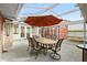 Screened patio features a dining table and an orange umbrella with a cute red outbuilding at 40 Hollow Pine Dr, Debary, FL 32713
