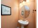 Charming powder room with pedestal sink, round mirror, and elegant light fixture at 411 Evening Sky Dr, Oviedo, FL 32765
