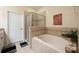 Relaxing bathroom features a soaking tub, glass shower, and neutral tile surround at 411 Evening Sky Dr, Oviedo, FL 32765