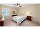 Neutral bedroom features a comfortable bed, ceiling fan and a window with shutters at 411 Evening Sky Dr, Oviedo, FL 32765