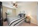 Bedroom featuring bed with striped linens, dark wood dresser, ceiling fan and shutters at 411 Evening Sky Dr, Oviedo, FL 32765
