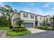 Beautiful townhome featuring a blue garage door, shutters, and manicured landscaping at 411 Evening Sky Dr, Oviedo, FL 32765