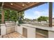 A fully-equipped outdoor kitchen featuring stainless steel appliances, a grill, a sink, and ample counter space under a covered patio at 4221 Isle Vista Ave, Belle Isle, FL 32812