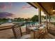 Covered patio dining area overlooking a pool and lake, perfect for outdoor entertaining and relaxation at 4221 Isle Vista Ave, Belle Isle, FL 32812