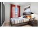 Bedroom featuring modern wood headboard, stylish bedding, and window with red sheer curtains for natural light at 4618 Linda Dr, Lake Wales, FL 33859