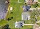 Overhead view of upscale houses featuring well-maintained lawns, a volleyball court, swimming pool, and private lake access at 49 Interlaken Rd, Orlando, FL 32804
