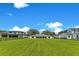 Large backyard showcasing a well-manicured lawn, surrounded by other homes and mature trees, creating a private oasis at 49 Interlaken Rd, Orlando, FL 32804