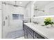 Bright bathroom featuring an illuminated mirror, walk-in shower, and gray vanity at 49 Interlaken Rd, Orlando, FL 32804