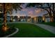 Picturesque home at sunset displaying a welcoming entrance, vibrant lawn, and sophisticated outdoor lighting for evening charm at 49 Interlaken Rd, Orlando, FL 32804