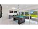 Bright game room features a pool table, wet bar, and sliding glass doors to the backyard and outdoor living space at 49 Interlaken Rd, Orlando, FL 32804