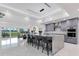 Modern kitchen featuring a marble island, gray cabinets, seating, and lake views at 49 Interlaken Rd, Orlando, FL 32804
