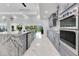 Open kitchen featuring a marble island, stainless steel appliances, and views of the backyard at 49 Interlaken Rd, Orlando, FL 32804