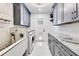 Bright laundry room with marble floors, gray cabinets, granite countertops, and a dog wash station at 49 Interlaken Rd, Orlando, FL 32804