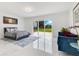 Spacious primary bedroom showcasing a sitting area with plush sofa, a bedroom suite and sliding glass doors with backyard views at 49 Interlaken Rd, Orlando, FL 32804