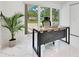 Bright home office features a modern desk, lush potted plant, and a large window with natural light at 49 Interlaken Rd, Orlando, FL 32804