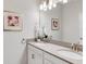 Well-lit bathroom featuring double sinks, granite countertops, modern lighting fixtures and framed art at 4984 Windermere Ave, Kissimmee, FL 34746
