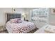 Cozy bedroom with a plush bed, soft lighting, and window offering a view of the landscape at 4984 Windermere Ave, Kissimmee, FL 34746