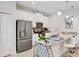 Modern kitchen boasts stainless steel appliances, sleek white cabinetry, a breakfast bar, and stylish pendant lighting at 4984 Windermere Ave, Kissimmee, FL 34746