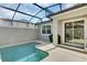 Backyard pool area featuring a grill, outdoor seating, privacy walls, and screened enclosure at 4984 Windermere Ave, Kissimmee, FL 34746