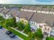 Aerial view of brightly painted townhomes, manicured lawns, mature trees, and sidewalks along a quiet street at 5029 Walker St, St Cloud, FL 34771