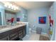 Well-lit bathroom boasts a double sink vanity with granite countertops and charming Spiderman themed decor at 5029 Walker St, St Cloud, FL 34771