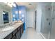 Modern bathroom with double sinks, granite countertop, glass-enclosed shower and stylish fixtures at 5029 Walker St, St Cloud, FL 34771