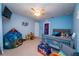 Bright, blue bedroom featuring a play tent, toys, and a charming crib filled with stuffed animals at 5029 Walker St, St Cloud, FL 34771