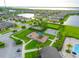 Aerial view of a community with a playground, basketball court, pool, lake, and well-maintained green spaces at 5029 Walker St, St Cloud, FL 34771