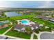 Aerial view of a community pool, lake, playground, and clubhouse with lush landscaping and ample recreational space at 5029 Walker St, St Cloud, FL 34771