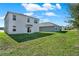 A spacious backyard featuring green grass and a view of the home's exterior at 5099 Marshelder St, Apopka, FL 32712