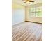 Bright bedroom with wood-look flooring and a large window offering natural light and outdoor views at 535 Aeolian Dr, New Smyrna Beach, FL 32168